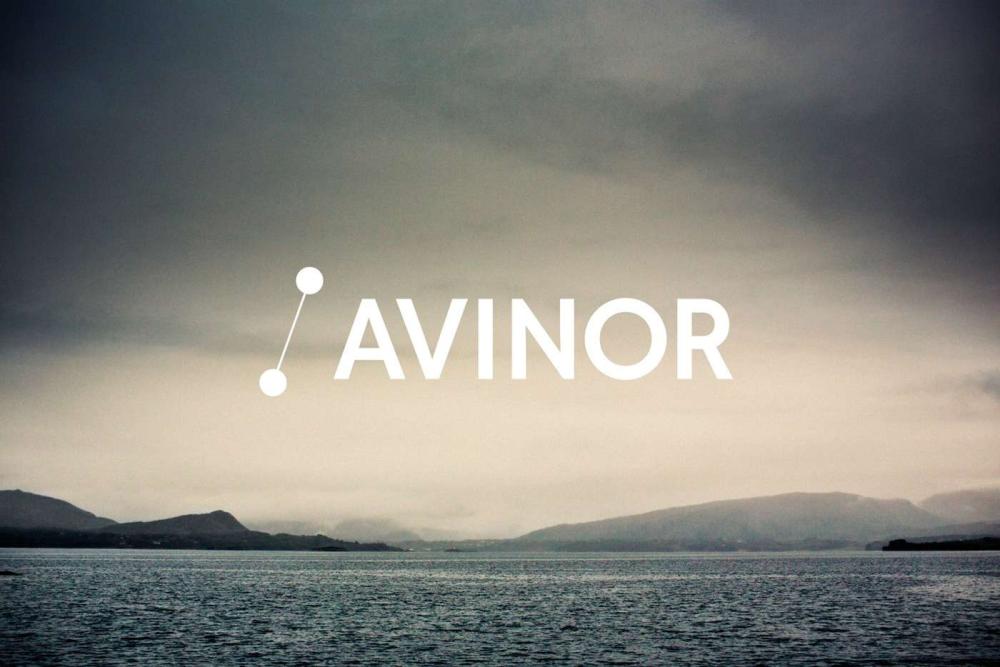 Avinor logo over en tåkete innsjø med fjell i bakgrunnen